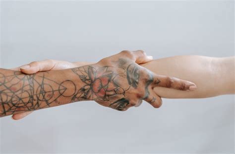 Man and Woman Interlocking Index Fingers With Anchor Tattoos · Free Stock Photo