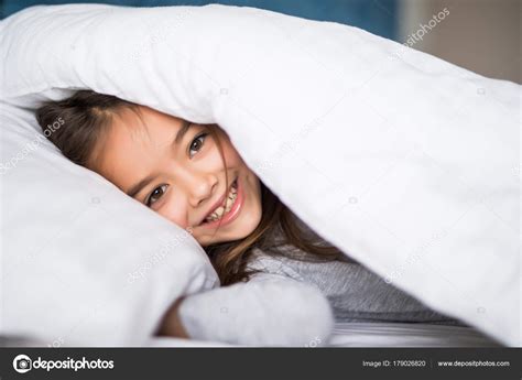 Girl lying under a blanket in the bed and smiling at home Stock Photo by ©dan.grytsku.gmail.com ...