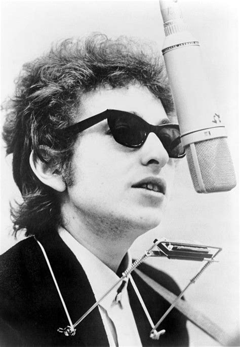 Bob Dylan (b. 1941) with harmonica, standing behind overhead microphone ...