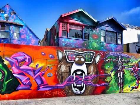 colorful graffiti on the side of a building with houses in the backgrouds