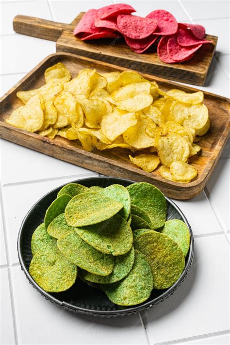 Premium Photo | Green potato chips on white ceramic squared tile table ...