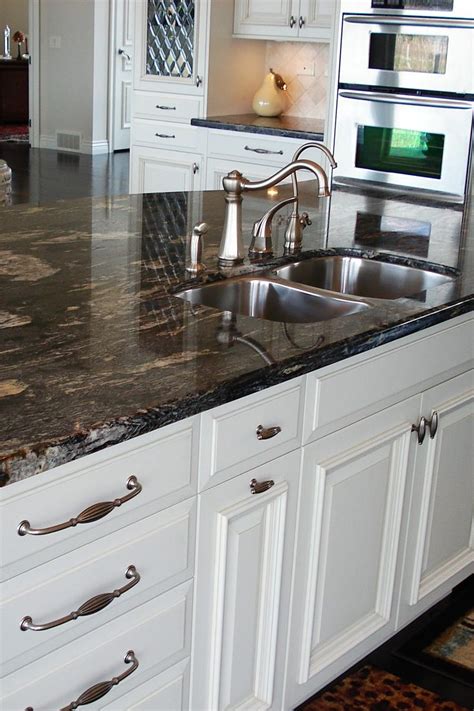 Titanium Granite Countertop White Cabinet Cream Backsplash Tile Dark Hardwood Floor | Granite ...