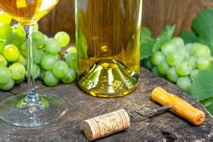 Top view of ripe grapes and white wine in bottle and glass on old wooden background - Creative ...