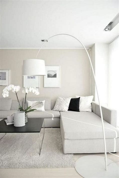 a neutral minimalist living room with an off-white sectional sofa, a ...