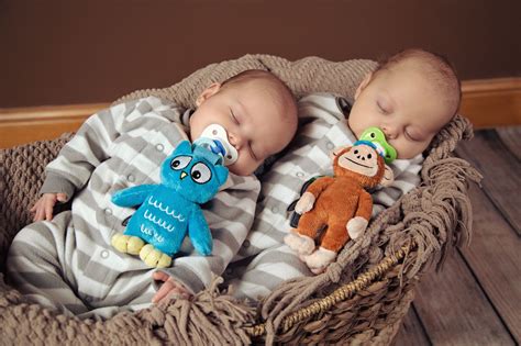 Newborn twins sleeping with their pacifiers and favorite accessories ...