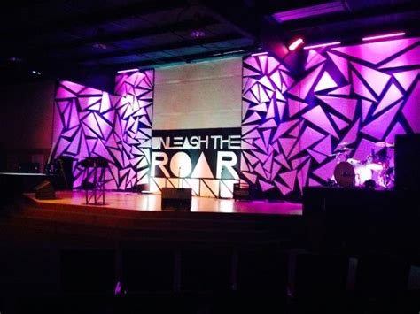 the stage is lit up with bright purple lights and an artistic backdrop that reads light the roar