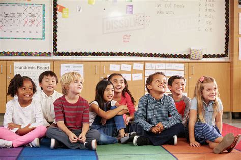 Elementary school kids sitting on classroom floor - Stock Photo - Dissolve