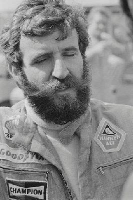 black and white photograph of a man with a beard wearing an old fashioned racing suit