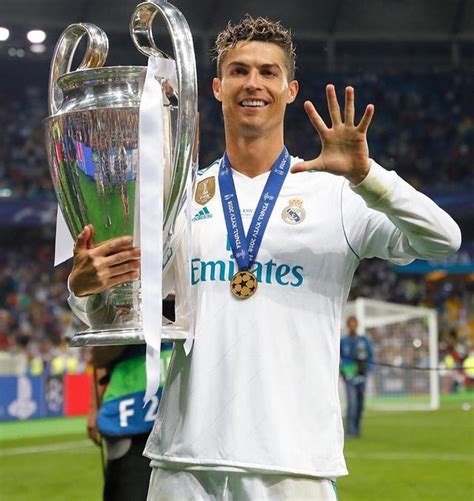 the soccer player is holding up his trophy and giving it to someone in front of him