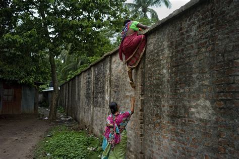 Two Bangladeshi women cross the border wall between India and ...