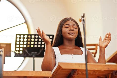 African american woman praying in the church. Believers meditates in the cathedral and spiritual ...