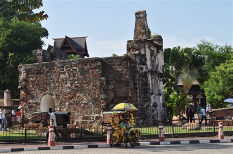 an old stone building with a yellow umbrella on the front and people standing around it