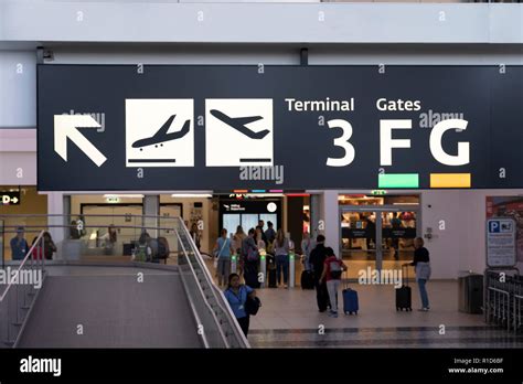 An illuminated sign at Vienna International Airport showing directions for arrivals, departures ...