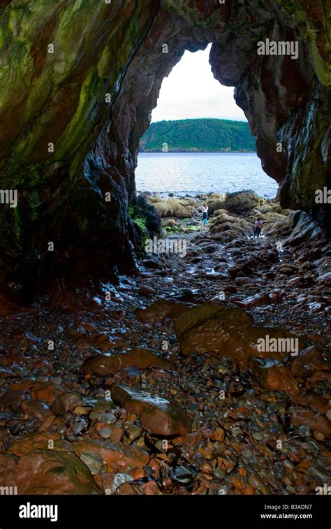 Two girls exploring a seaside cave on the shores of the Cromarty Firth, Scotland Stock Photo - Alamy