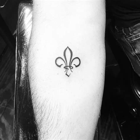 Minimalistic style fleur de lis tattoo located on the