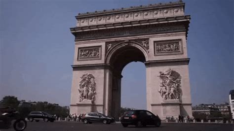 cars are parked in front of the arc de trio triumphe, which is also known as the arch of triumph