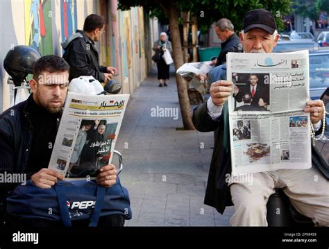 Lebanese men, read newspapers with front pages pictures showing the ...