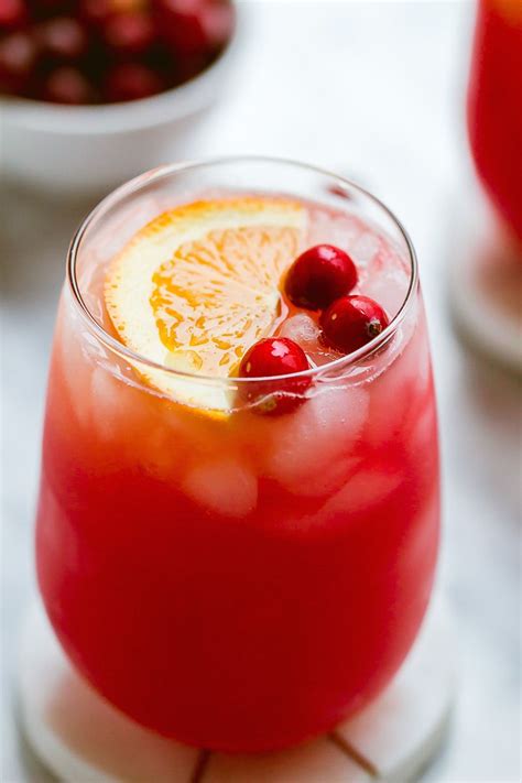 a drink with orange slices and cranberries in it