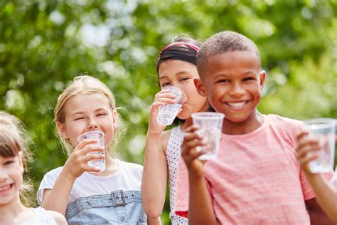 Children with plastic cups drinking water in summer in the park - Clackamas River Water