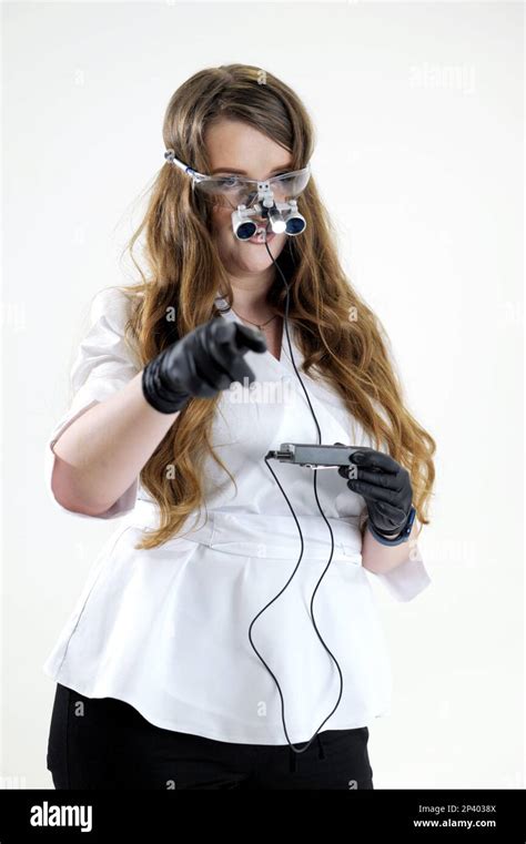 Dentist in binoculars in a white medical suit on a white background advertising stomatology ...