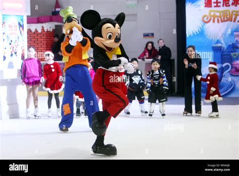 Mickey Mouse and Goofy skate in front of kids at a press conference for ...