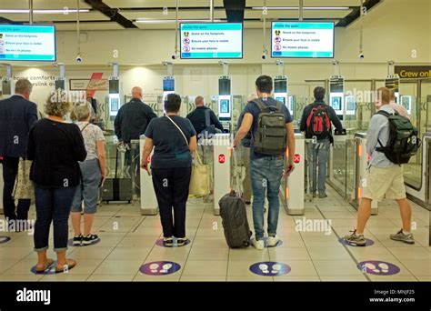 people arriving and entering UK through the e-passport border passport control gates at gatwick ...