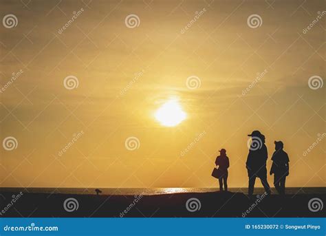 Silhouette Of People Standing And Walking On The Beach With Sunset Background Stock Photo ...