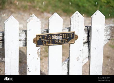 Please close gate sign on white wooden fence Stock Photo - Alamy