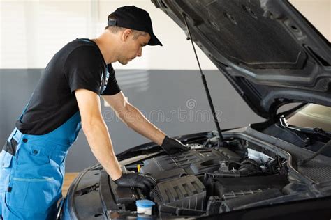 Mechanic Man Open a Car Hood and Check Up the Engine. Car Mechanic Noting Repair Parts during ...