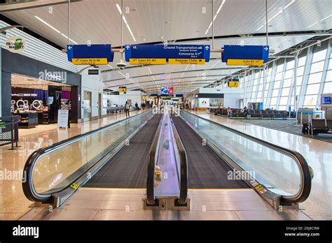 Airport terminal with two moving sidewalks and distant people Stock Photo - Alamy