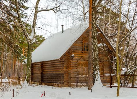 Premium Photo | A wooden house in the woods covered in snow