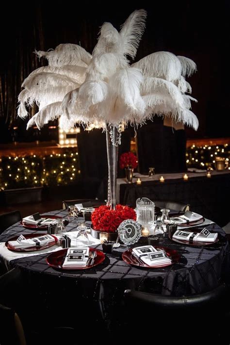 the centerpiece is decorated with white feathers and red roses