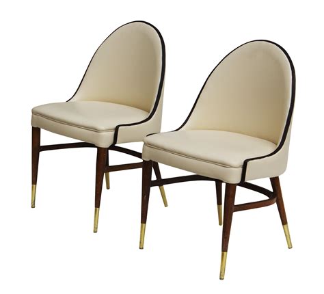 Petite pair of curved back chairs upholstered in cream vinyl and tipped in dark brown ...