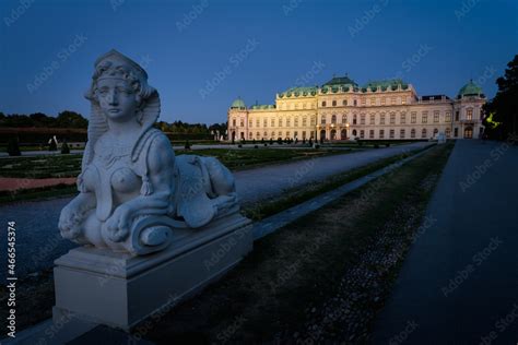 Famous Belvedere castle (Schloss Belvedere) surrounded by gardens with classic statues at night ...