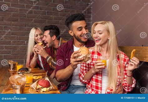 People Group Eating Fast Food Burgers Sitting at Wooden Table in Cafe ...