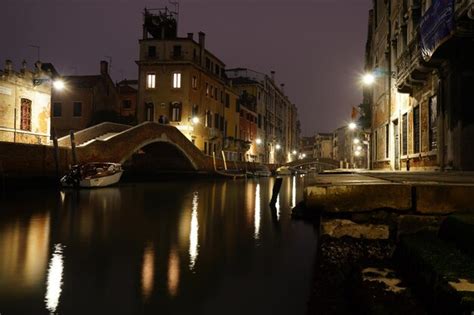 Premium Photo | Reflection of buildings in water at night