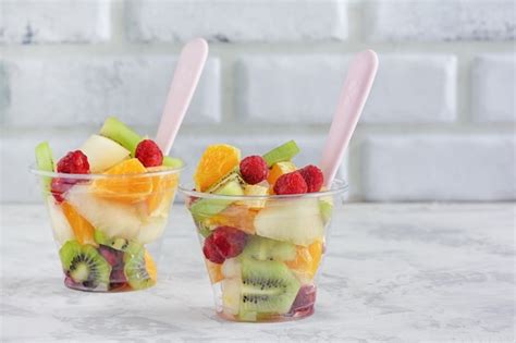 Premium Photo | Fresh assorted fruit salad in takeaway plastic cup