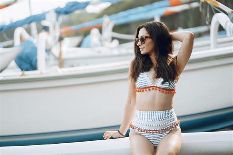 Positive woman in swimsuit sitting on yacht side · Free Stock Photo