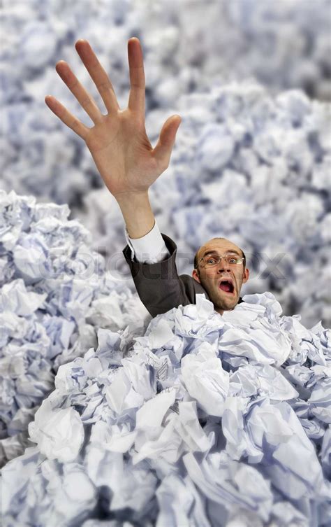 Businessman sinking in big heap of crumpled papers | Stock image | Colourbox