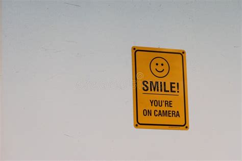 Cheerful Yellow Sign with an Encouraging Message of Smile, You Re on Camera on a White Wall ...