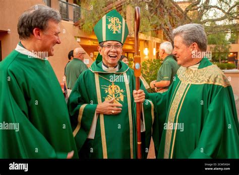 Wearing green ceremonial vestments, the deacon and monsignor of a ...