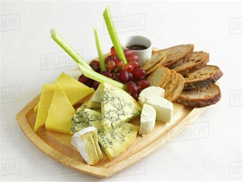 A cheese platter with bread, grapes and celery - Stock Photo - Dissolve