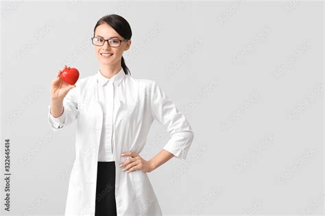 Female cardiologist on light background Stock Photo | Adobe Stock