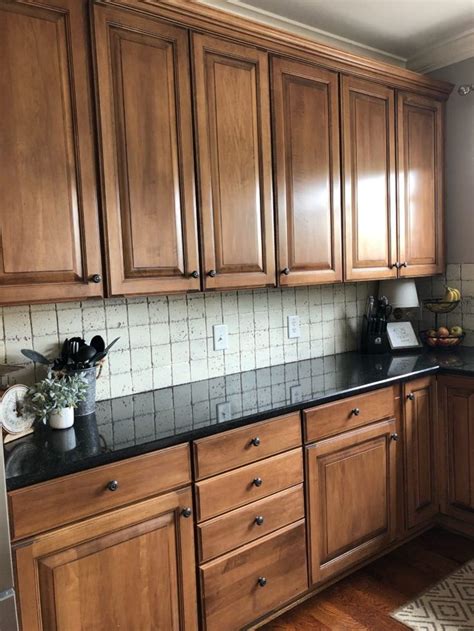 a kitchen with wooden cabinets and black counter tops