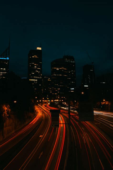 Time Lapse Photo of Lighted Highway at Night With Buildings in Background · Free Stock Photo