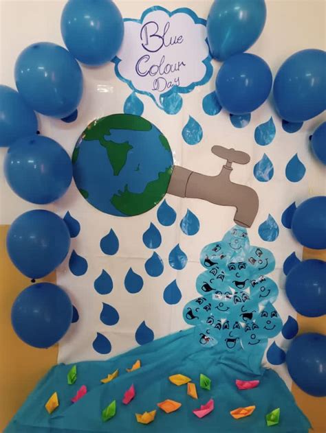 a blue earth themed birthday party with balloons and streamers on the wall, water coming out ...