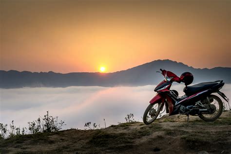 Red and Black Underbone Motorcycle on Mountain Cliff Surrounded by Sea of Clouds · Free Stock Photo