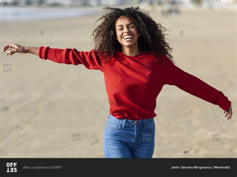 Portrait of laughing young woman on the beach stock photo - OFFSET