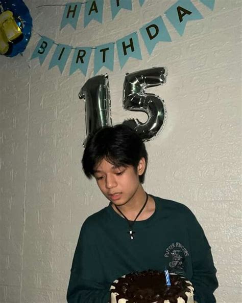 a boy holding a birthday cake in front of his face with the number five on it