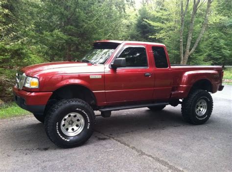 a red pick up truck parked in front of some trees